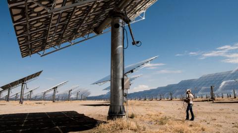 Person inspecting concentrated solar reflectors