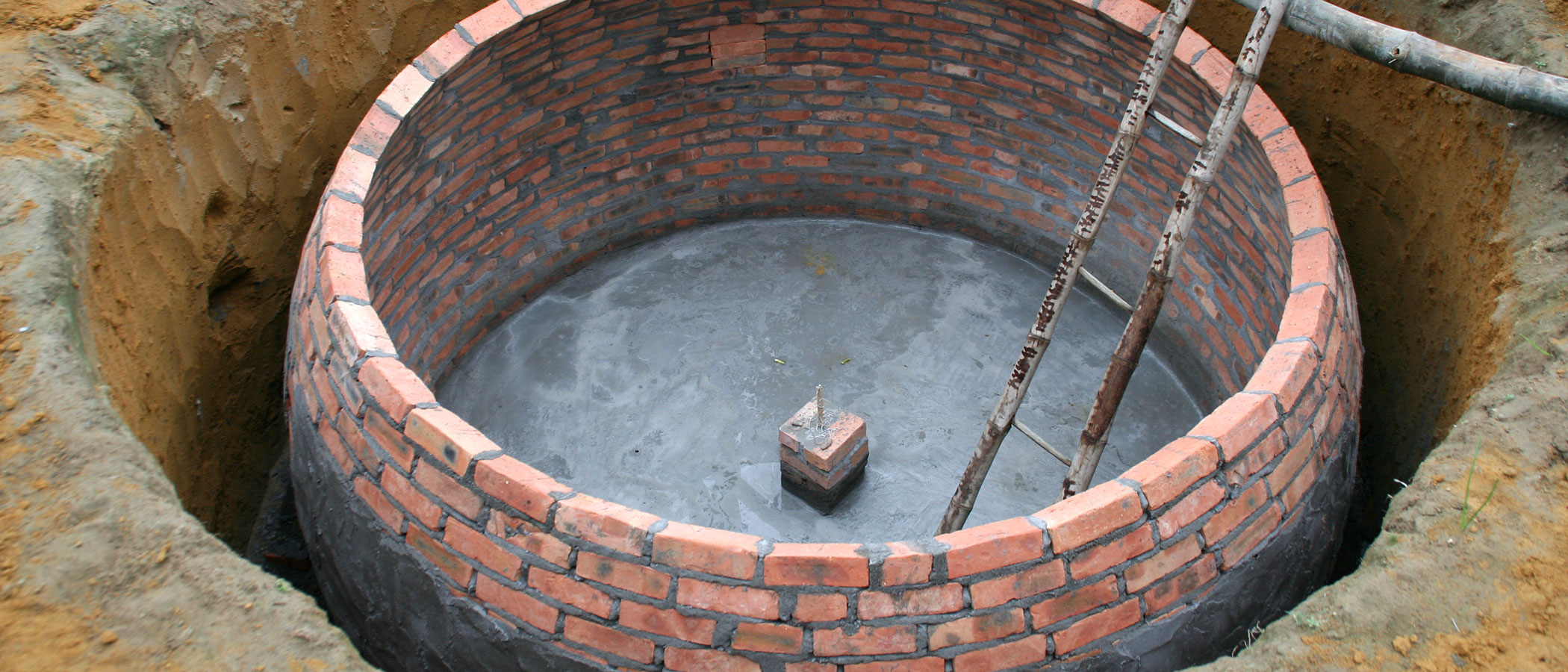 Small-scale biogas plant made of brick and cement then buried below ground.