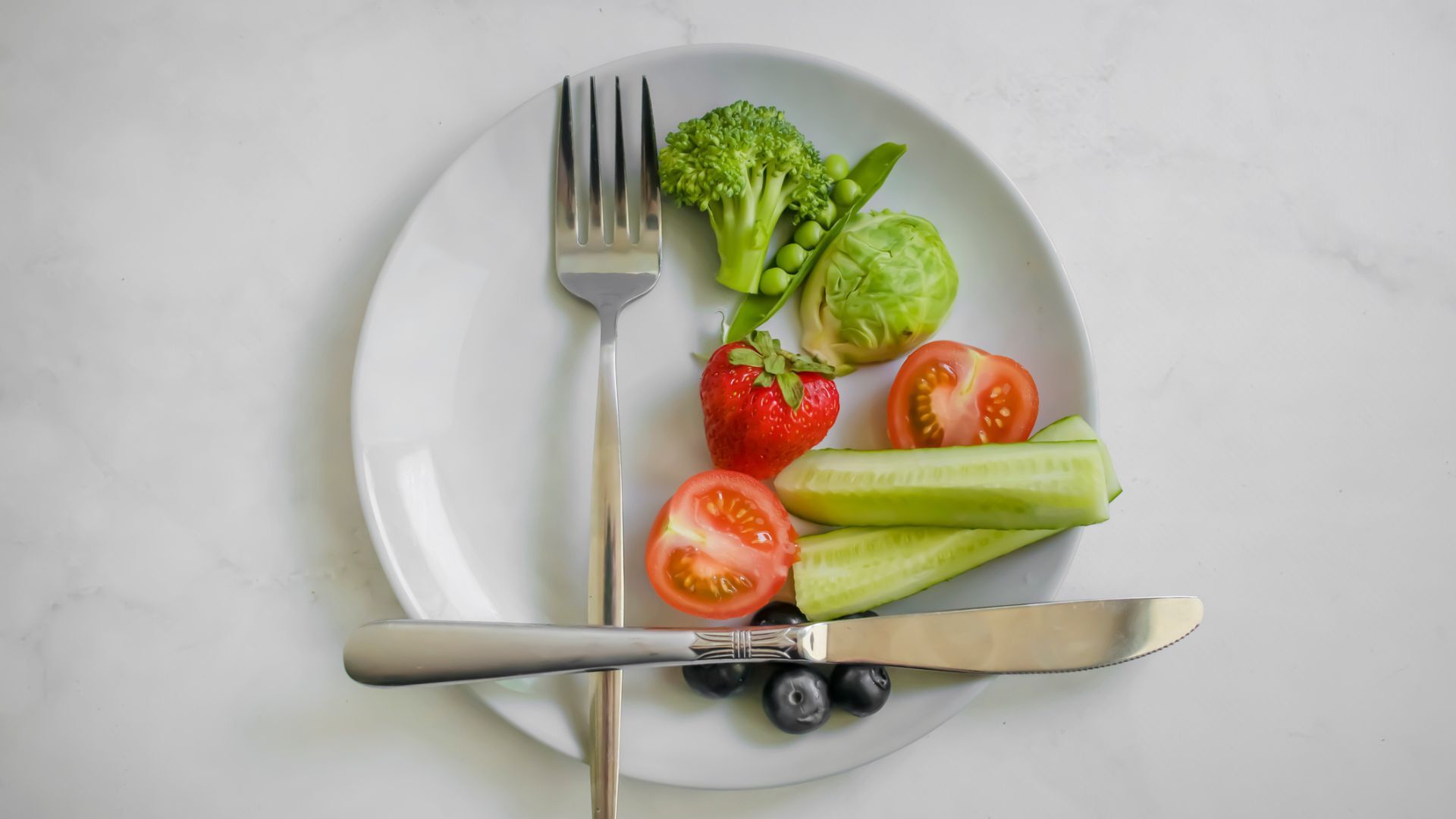 A plate half-filled with vegetables and fruit