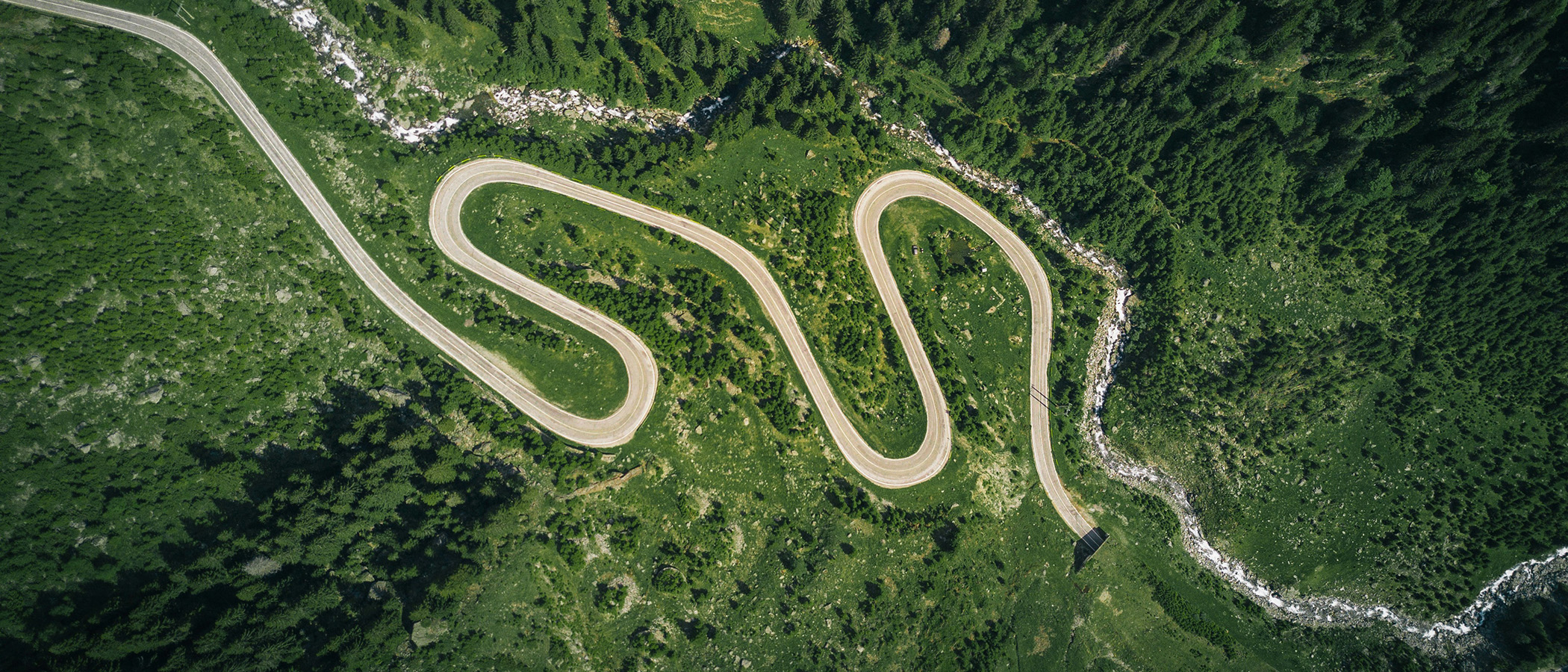 A road running through a green mountainous area