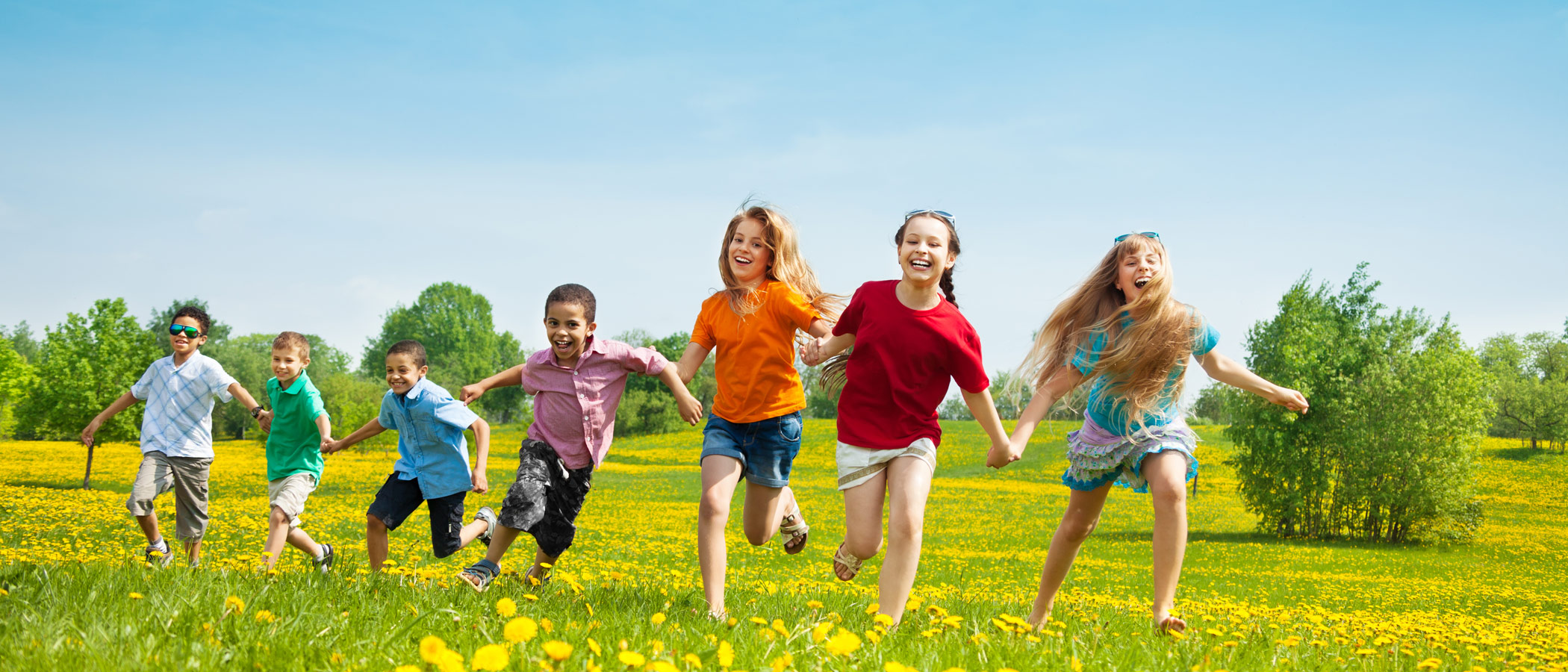 Children running in a field of flowers
