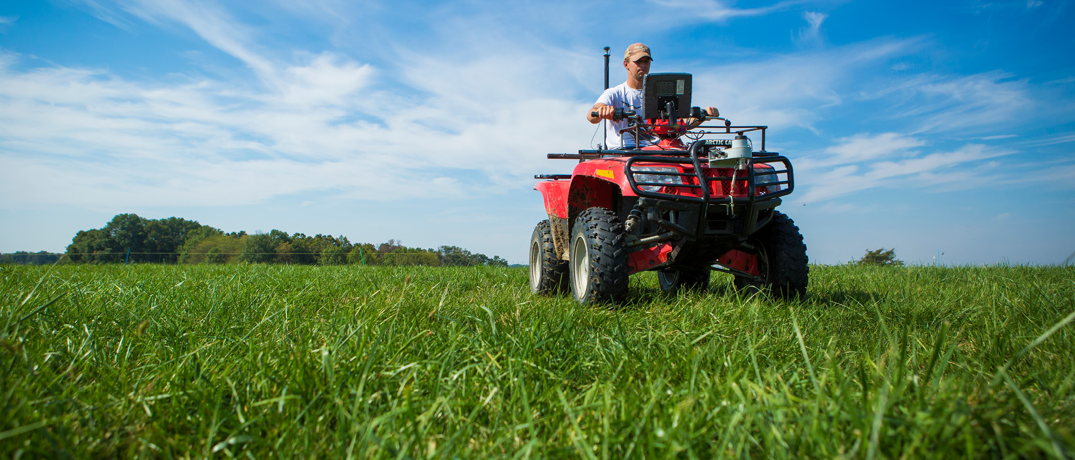 Person riding an ATV with sensors to measure pasture growth