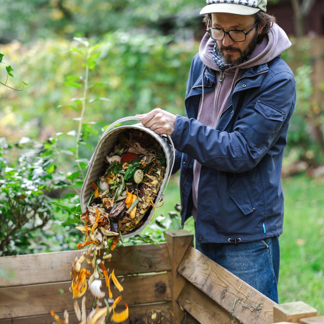 Person pouring food waste into compost bin