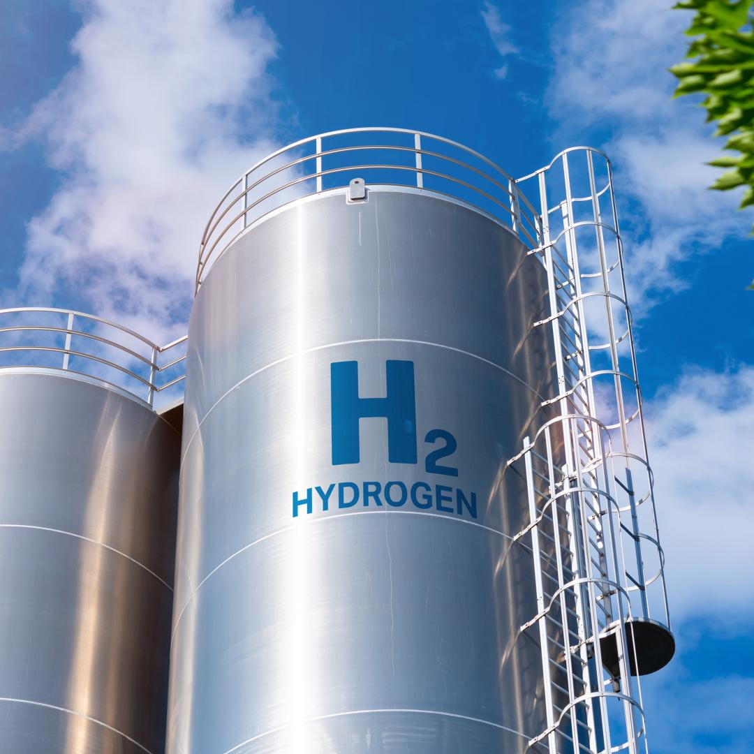 An image of a large, metal hydrogen storage tank that says 'H2 Hydrogen' on the side