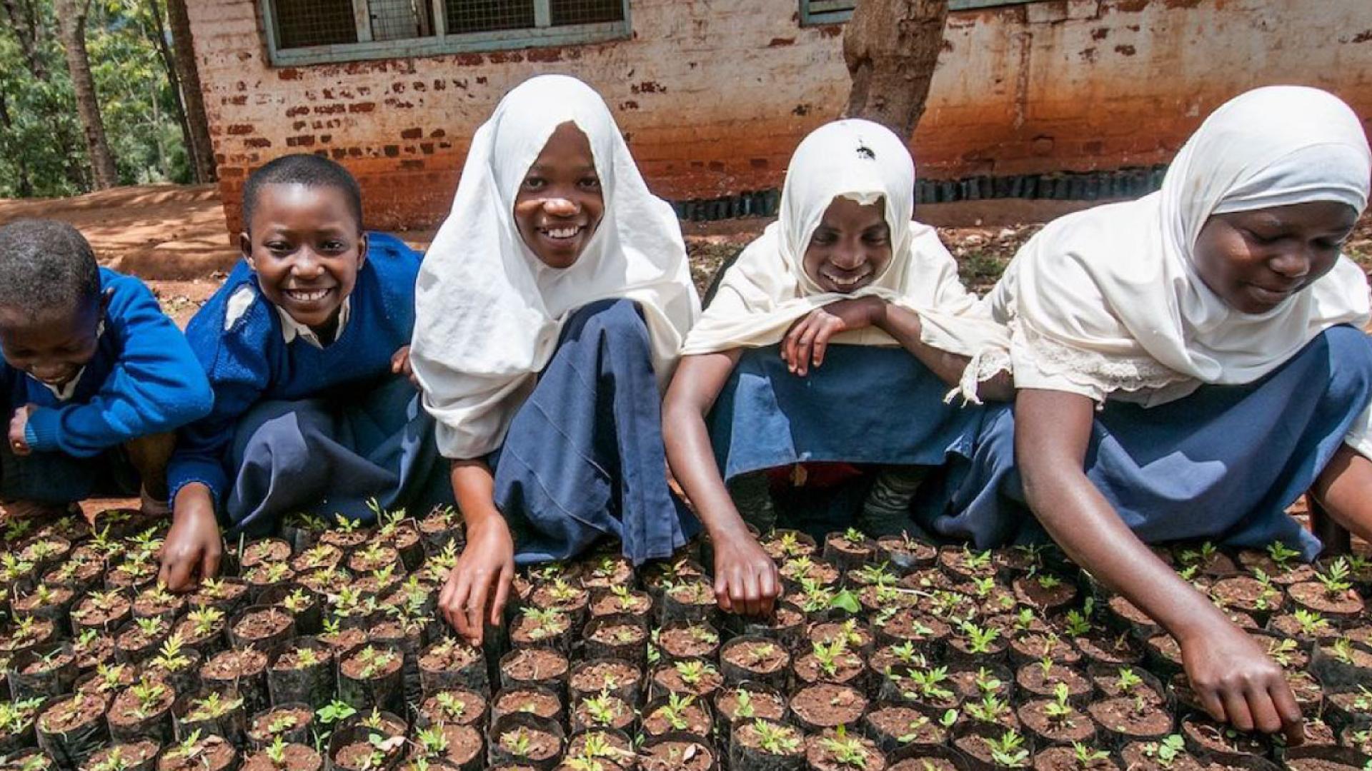 Young people planting seeds and smiling