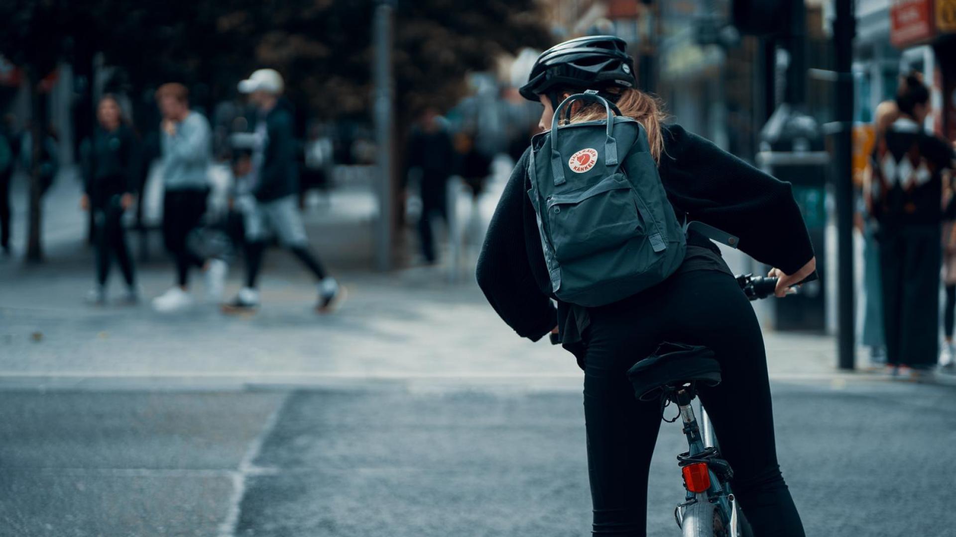 A woman in a helmet riding a bike to work