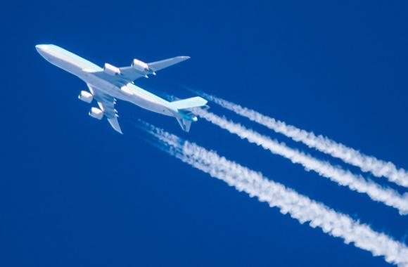 An image of an airplane with contrails