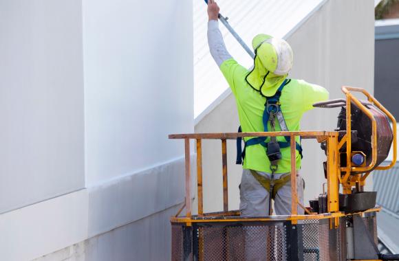 Worker coating a surface with white material